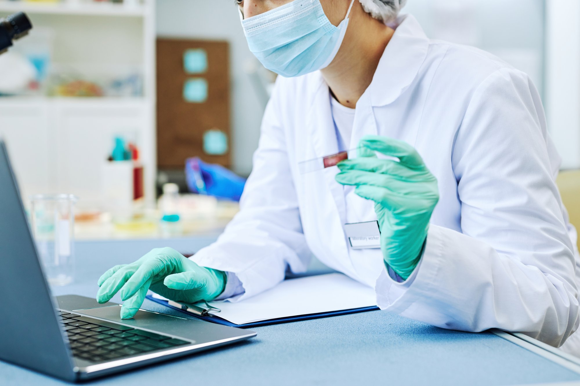 stambiu planu dirbanti moteris, dirbanti šiuolaikinėje laboratorijoje, atliekanti kraujo tyrimus, kopijuojanti erdvę