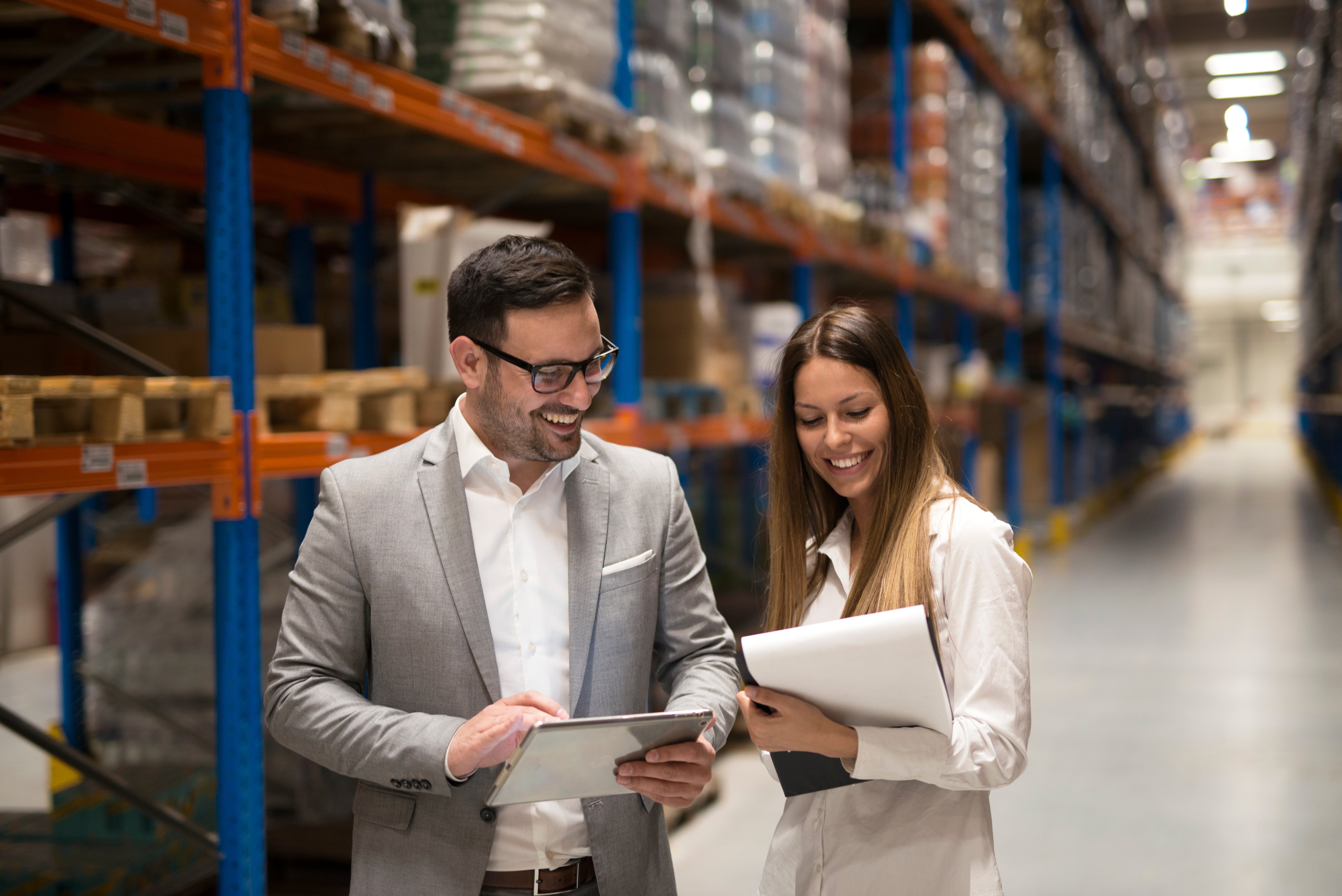 Smiling managers visiting warehouse to see if workflows follow gdp certification requirements 