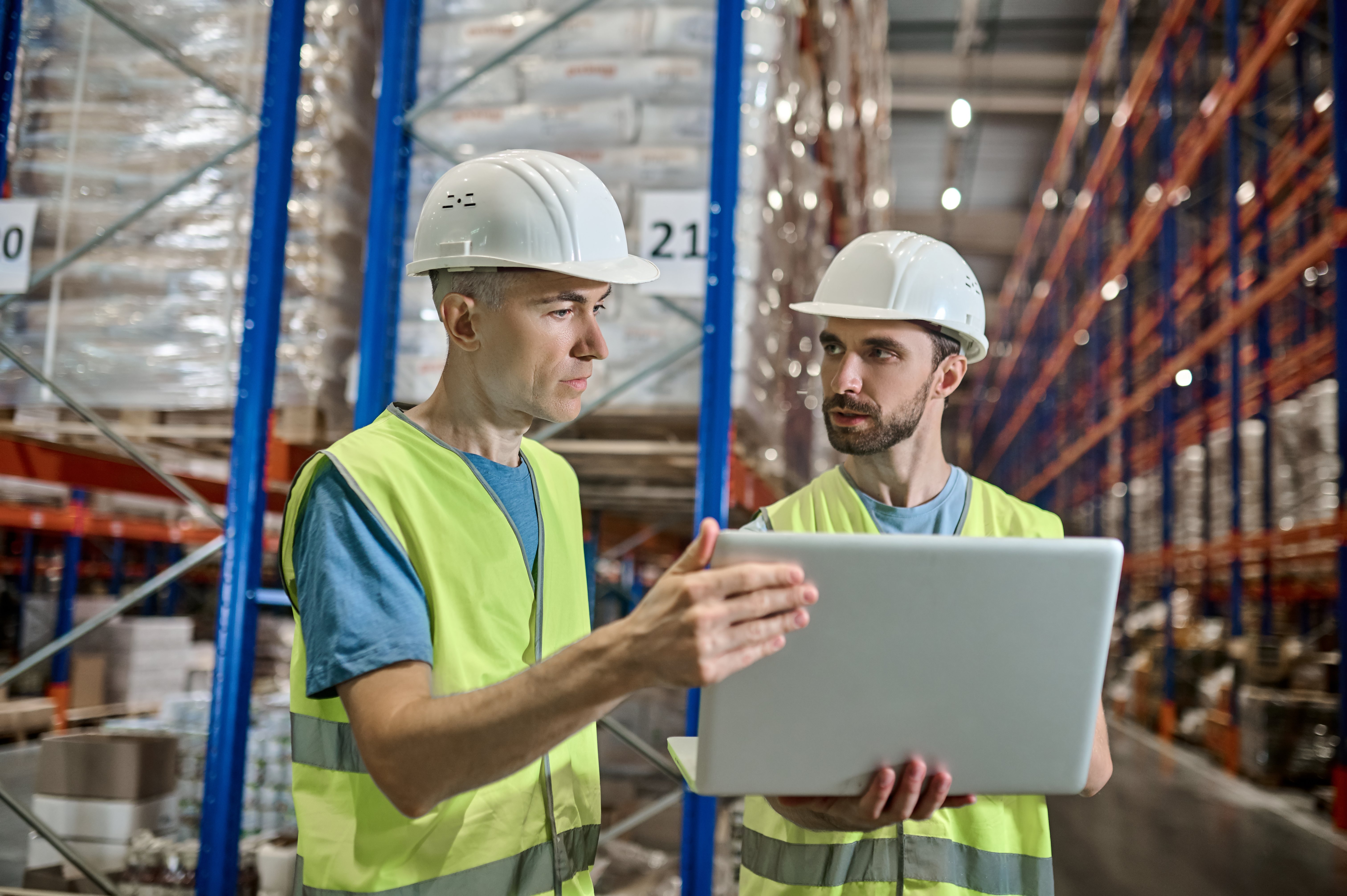 Workers in warehouse discussing transportation following gdp guidelines