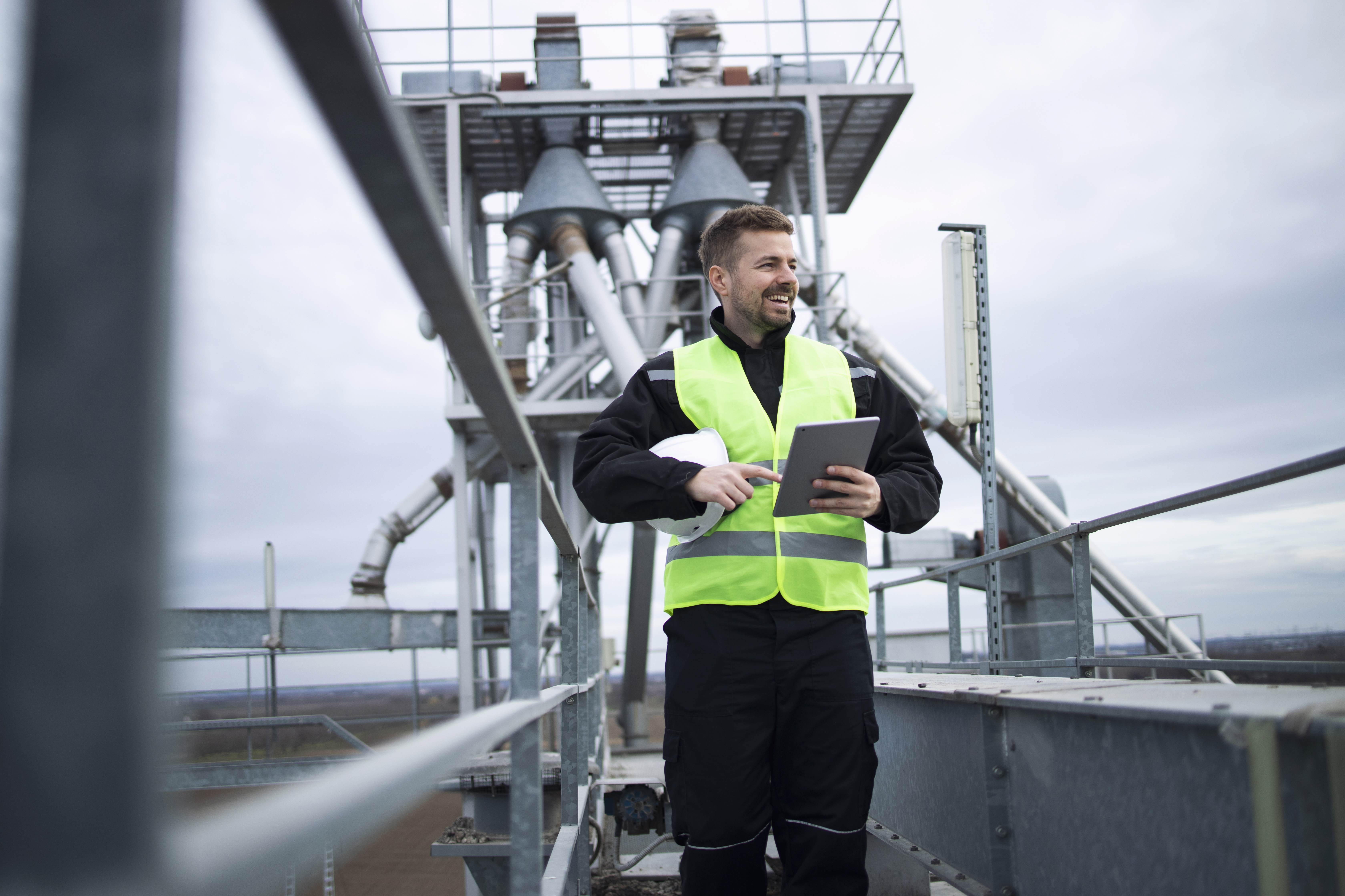 industrial-oil-worker-smiling-metal-construction-tablet-rig[used-on-oil-gas-page]