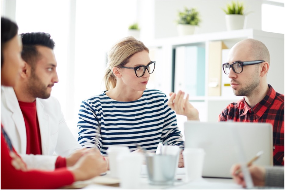 Employees sitting around a table sharing ideas on what needs to be done to become gdp compliaint