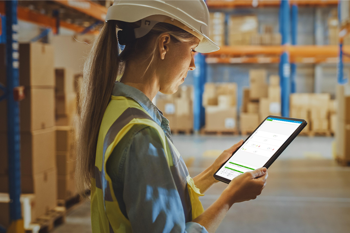 Employee in warehouse with tablet works in an eqms for GDP compliance